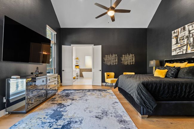 Bedroom with light wood-type flooring, high vaulted ceiling, and ensuite bath | Image 14