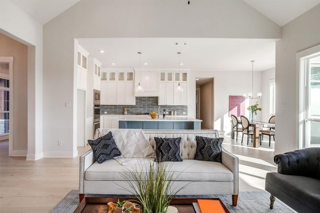 Living room featuring lofted ceiling, an inviting chandelier, and light hardwood / wood-style flooring | Image 13