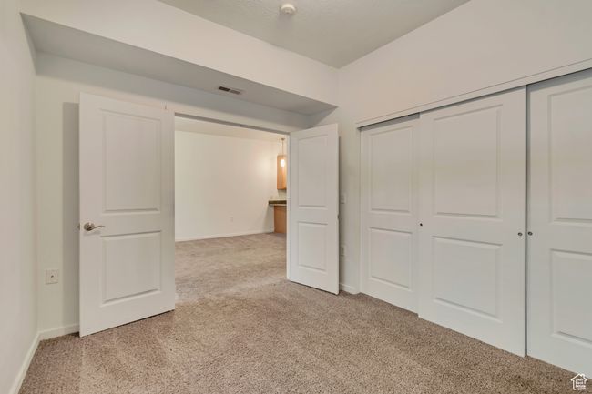 Unfurnished bedroom featuring a closet, baseboards, visible vents, and light carpet | Image 13