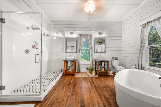 Full bathroom with wood-type flooring, a freestanding tub, a shower stall, ceiling fan, and ornamental molding | Image 18