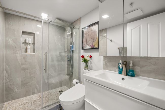 Full bathroom with toilet, vanity, a stall shower, and decorative backsplash | Image 24