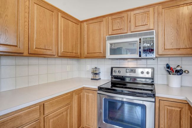 Kitchen featuring appliances with stainless steel finishes, backsplash, and light countertops | Image 14