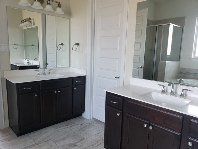 Full bathroom featuring a shower stall, two vanities, and a garden tub | Image 14