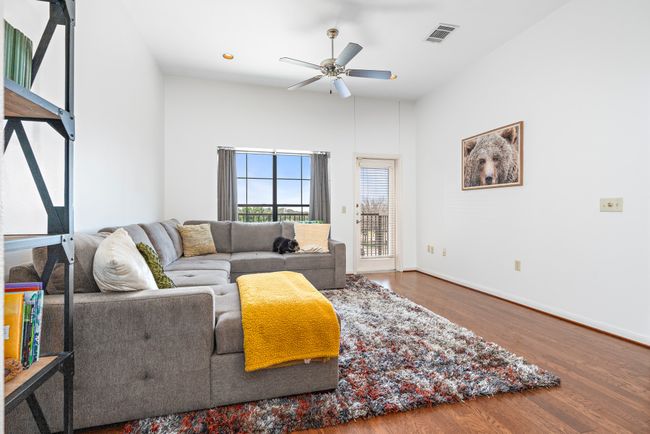 Living room featuring a ceiling fan, wood finished floors, and baseboards | Image 8