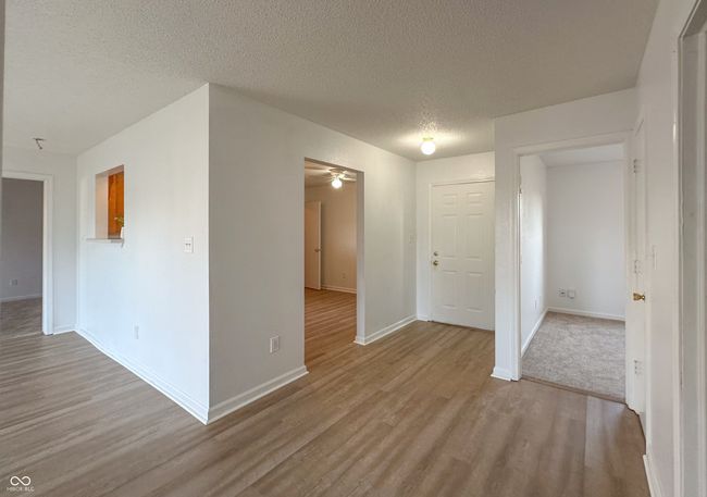 unfurnished room featuring a textured ceiling, wood finished floors, baseboards, and a ceiling fan | Image 18