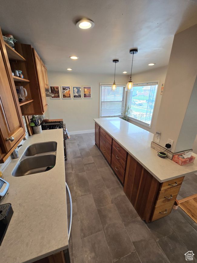 Kitchen with recessed lighting, open shelves, light countertops, range hood, and a sink | Image 43