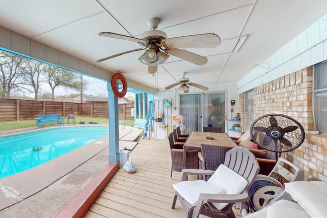 View of swimming pool featuring a fenced backyard, a fenced in pool, ceiling fan, and a wooden deck | Image 32