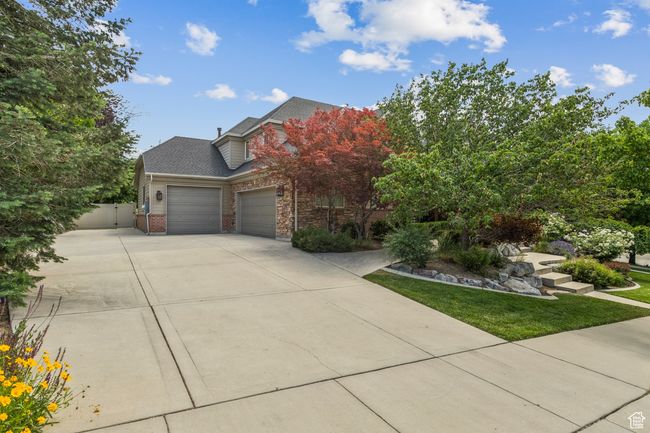 View of front of home with a garage, concrete driveway, brick siding, a gate, and a shingled roof | Image 71