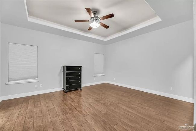 Unfurnished room featuring a tray ceiling, ceiling fan, and wood-type flooring | Image 13