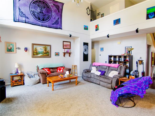 Living area featuring carpet floors, a high ceiling, and baseboards | Image 6