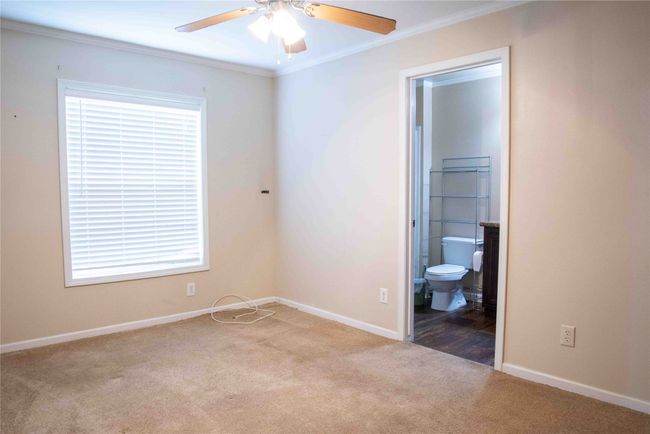 Master bedroom featuring crown molding, baseboards, carpet, and connected bathroom | Image 27