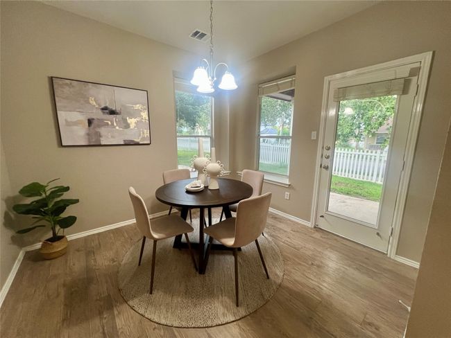 Dining area featuring a chandelier and wood finished floors | Image 18