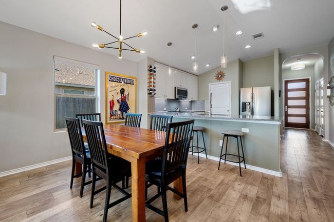 Dining area with arched walkways, lofted ceiling, visible vents, and light wood-type flooring | Image 6