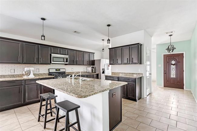 This image shows the kitchen featuring a large island. | Image 12