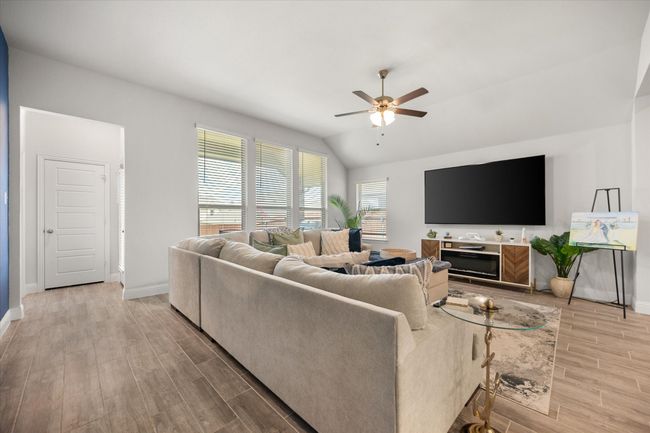 Living room featuring a ceiling fan, light wood-style floors, and vaulted ceiling | Image 10