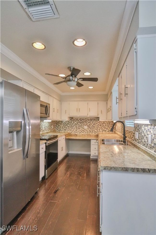 Kitchen with appliances with stainless steel finishes, a sink, crown molding, recessed lighting, and dark wood-type flooring | Image 22