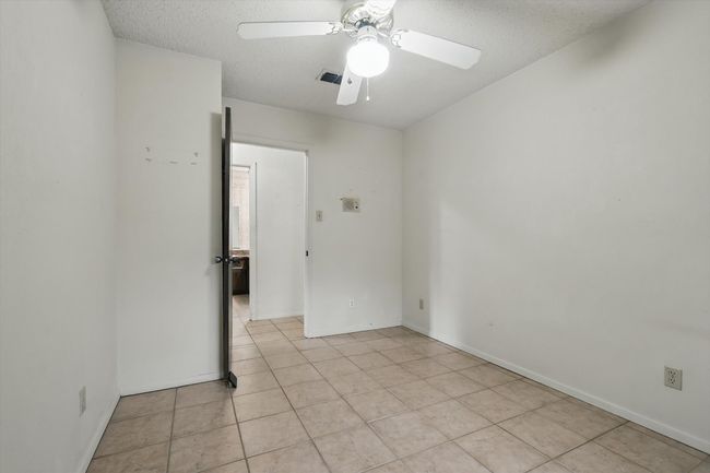 Spare room with a ceiling fan, a textured ceiling, light tile patterned floors, and baseboards | Image 31