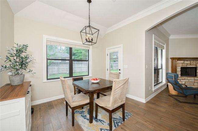 Dining space with crown molding, hardwood / wood-style floors, a chandelier, and baseboards | Image 14