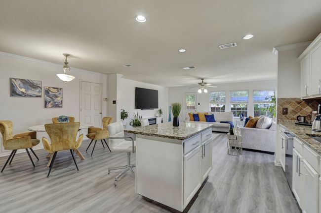 Kitchen featuring light hardwood / wood-style floors, tasteful backsplash, ceiling fan, white cabinetry, and pendant lighting | Image 15