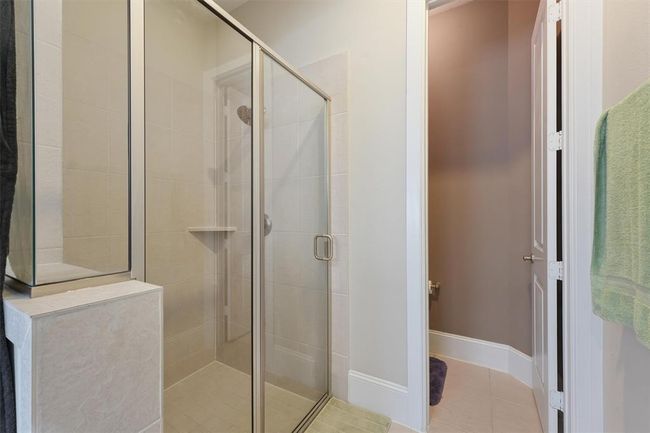 The primary bathroom includes a spacious walk-in shower with tile surround and glass enclosure, along with a private water closet for added comfort and functionality. A well-designed space for daily ease and relaxation. | Image 18