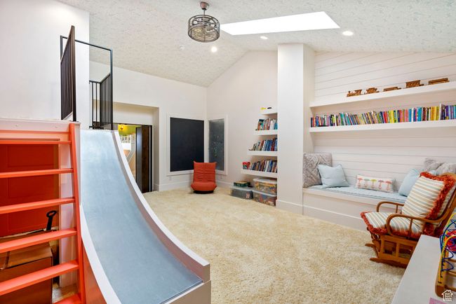 Playroom featuring vaulted ceiling with skylight, recessed lighting, carpet floors, and a textured ceiling | Image 50