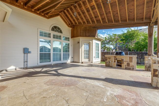 View of patio with outdoor dry bar, fence, and an outdoor kitchen | Image 24