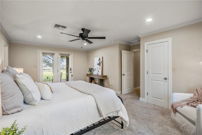 Bedroom featuring baseboards, visible vents, light colored carpet, access to exterior, and crown molding | Image 33