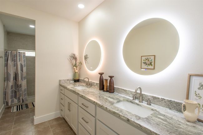 Bathroom with a shower with shower curtain, vanity, and tile patterned floors | Image 33