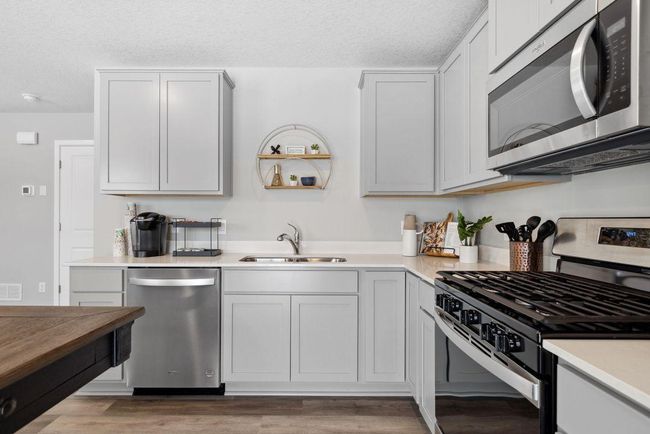 Stainless steel appliances and quartz countertops. Photo is of model home. Colors and options may vary. Ask Sales Agent for details. | Image 6