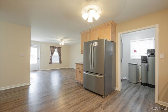 Kitchen featuring light brown cabinets, dark wood-style flooring, ceiling fan, and freestanding refrigerator | Image 11