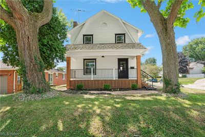 View of front property with a porch, a garage, and a front lawn | Image 2