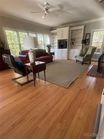 Living room featuring ceiling fan, plenty of natural light, light hardwood / wood-style flooring, and ornamental molding | Image 3