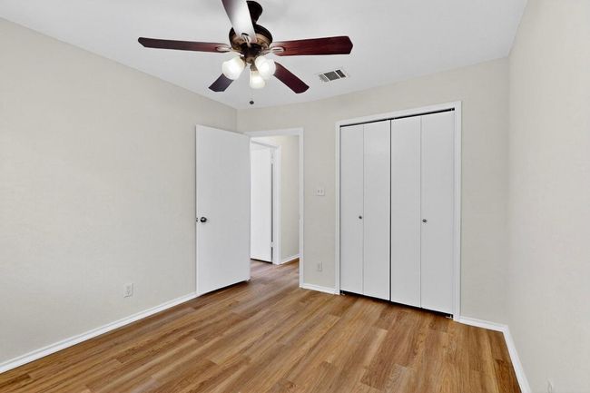 Unfurnished bedroom with light wood-style flooring, baseboards, a closet, and ceiling fan | Image 23