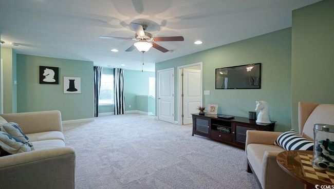 Carpeted living area with a ceiling fan, baseboards, and recessed lighting | Image 30