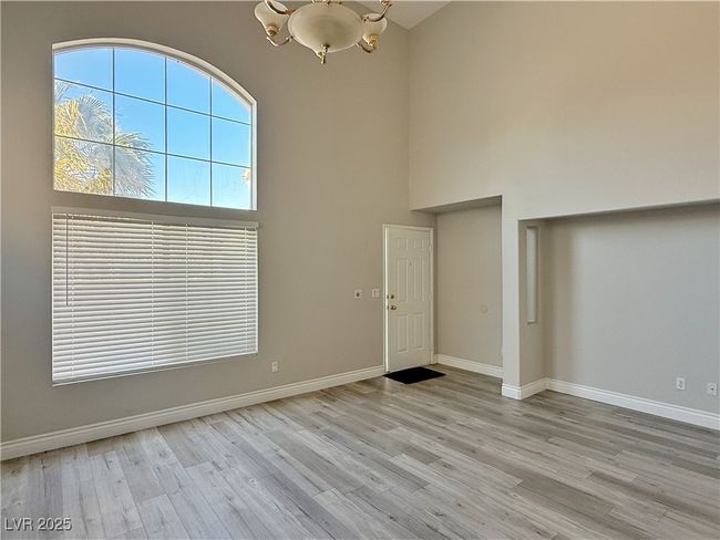 Foyer with baseboards, a high ceiling, an inviting chandelier, and wood finished floors | Image 4