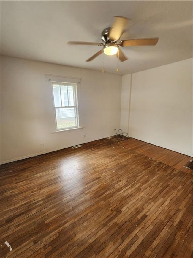 Unfurnished room with dark wood finished floors, visible vents, and ceiling fan | Image 14