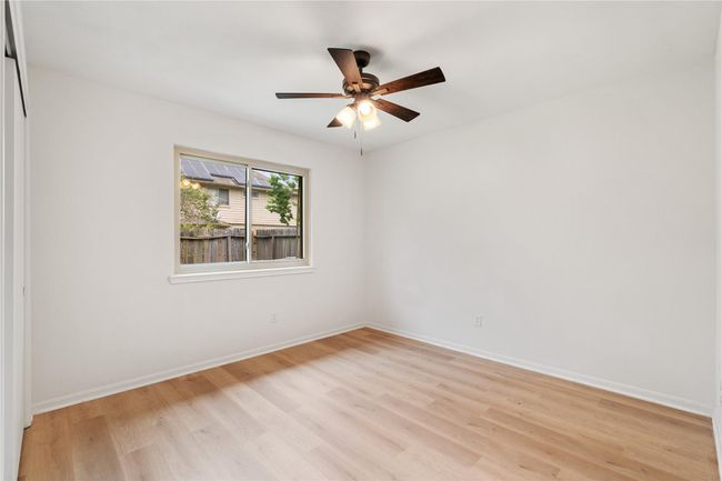 Secondary bedroom with simple lines, clean flooring, and natural light from side window. | Image 19