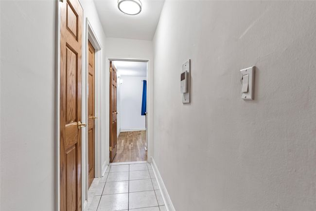 Hall with light tile patterned floors and baseboards | Image 9
