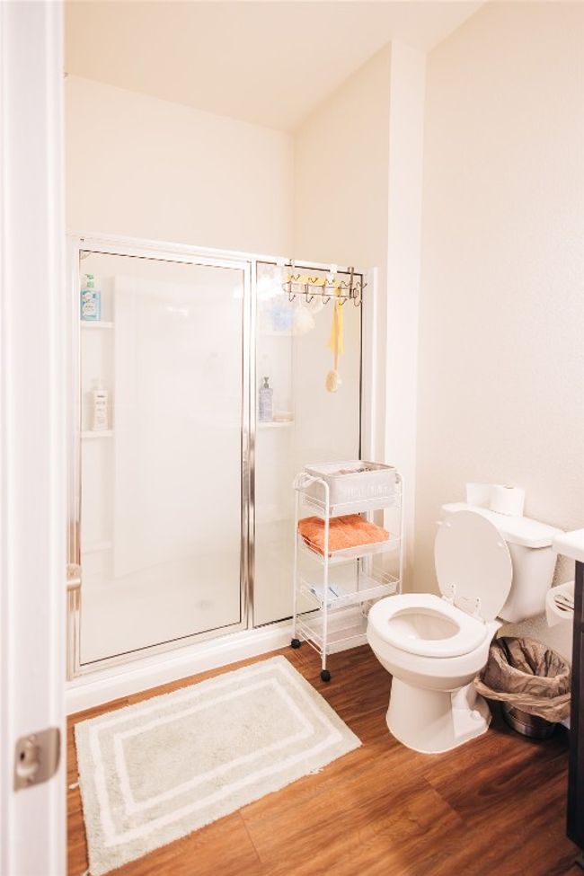 Full bath with wood finished floors, a shower stall, and toilet | Image 10