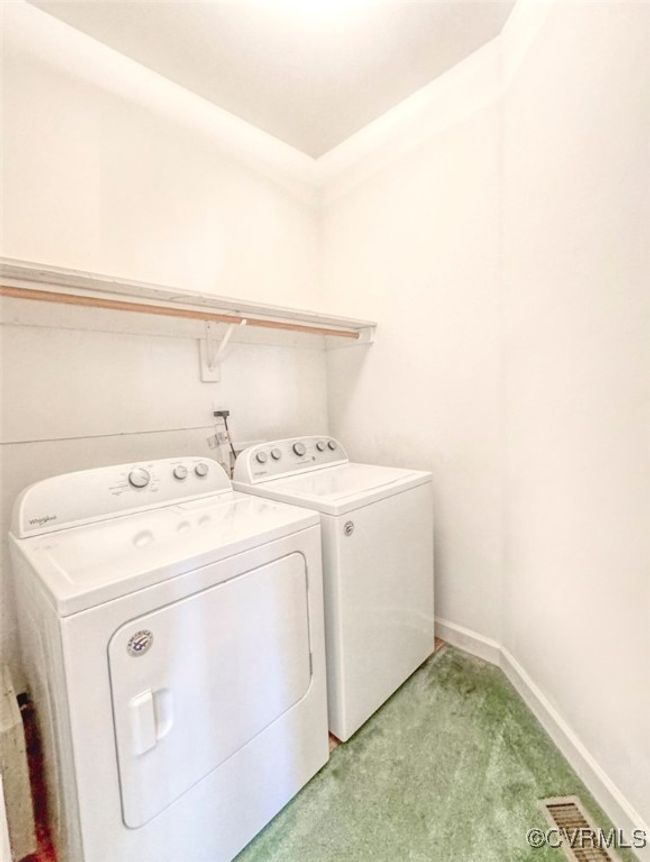 Laundry area featuring separate washer and dryer, laundry area, light colored carpet, baseboards, and visible vents | Image 29