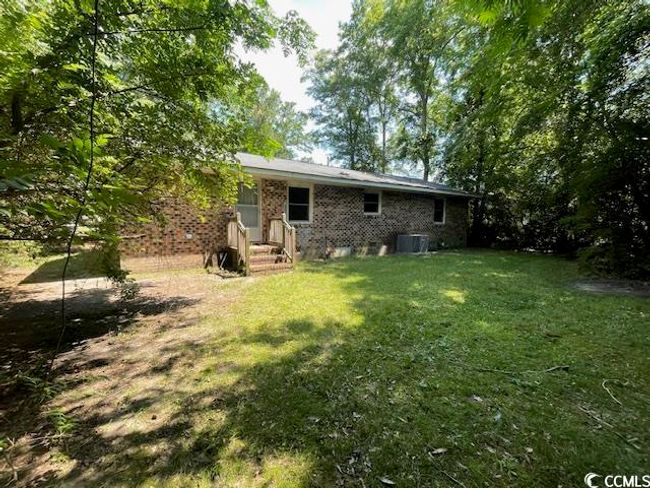 Back of house featuring a lawn, central air condition unit, and brick siding | Image 7