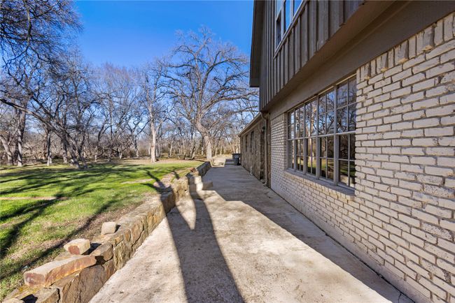 View of side of property featuring a yard, brick siding, and a patio area | Image 22