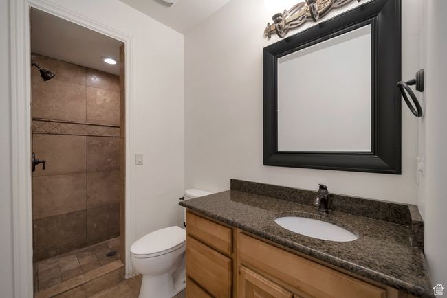 Bathroom featuring vanity, toilet, and tiled shower | Image 25