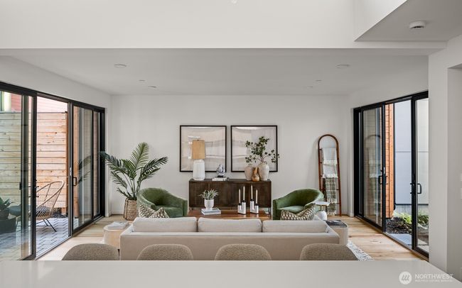 This spacious living room is enhanced by expansive sliding glass doors and windows, seamlessly blending indoor and outdoor living while flooding the space with abundant natural light. | Image 7