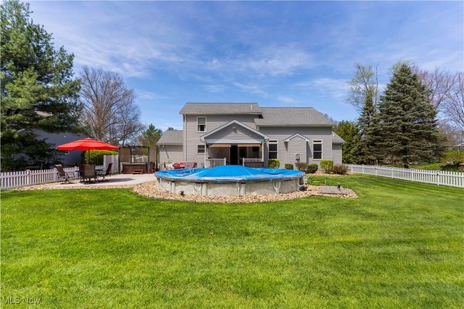 Rear view of property w/ partial in ground pool & hot tub | Image 36