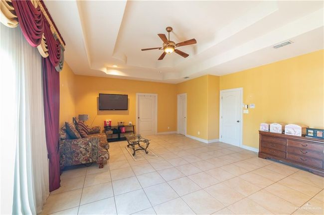 Sitting room featuring a tray ceiling, light tile patterned floors, and ceiling fan | Image 23