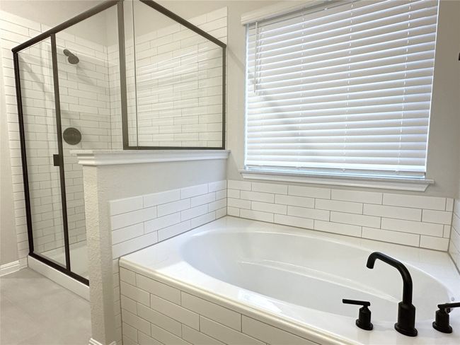 Full bath featuring a garden tub, a stall shower, and tile floors | Image 11