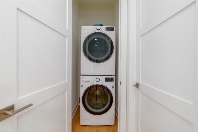 Laundry room with stacked washer / dryer and light wood-type flooring | Image 11