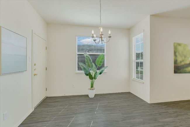 Dining area featuring plenty of natural light, wood finished floors, and a chandelier | Image 15