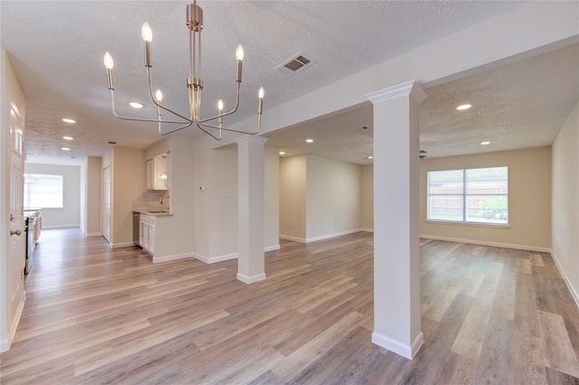 Formal dining looking toward kitchen and family room. The interior spaces have been opened as much as possible to allow for better natural light and openness. | Image 4